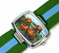 Dachshund Watch features two charming Dachshunds sitting against a grassy backdrop on watch face with olive green and blue stripe watch band. Matches Dachshund Purse 1.
