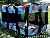 Pet Carrier 1 is a sturdy framed sherpa type pet carrier with detachable shoulder strap in bright blue with red dots.