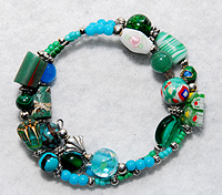 PugSpeak Bracelet 14 with a variety of Lampwork, gemstone, and African wood beads on memory wire