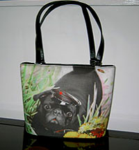 Pug Purse 16 is a Microfiber pug handbag features a black pug in a cap against a grassy background and measures 9.50" X 2.50" X 8.00" (24.13 X 6.35 X 20.32 cm). This pug handbag also offers  shoulder straps.