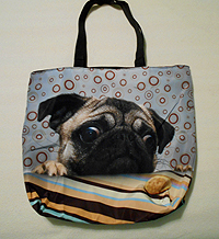 PugSpeak Pug Purse 37 or tote measures 17.00" X 14.50" (43.18 X 36.83 cm) and is large enough to carry books and/or tablet! A cute pug gazes at a cookie against a retro gray, gold, and aqua background. There is also a zippered inner compartment and black shoulder straps.